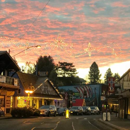 A charming street scene at sunset, with festive lights spelling "Fortuna" and colorful clouds in the sky.