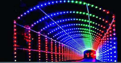 A colorful illuminated tunnel with red, green, and blue lights creating a vibrant, festive atmosphere.