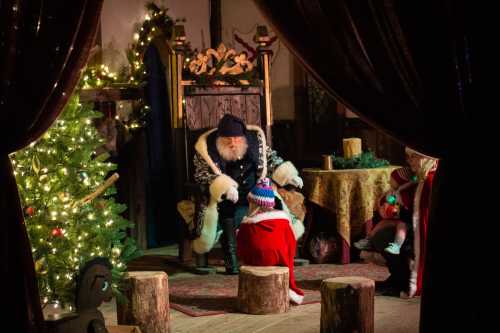 A cozy holiday scene with Santa sitting on a throne, a child in a red outfit, and a decorated Christmas tree nearby.