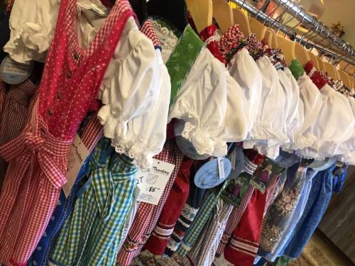 A colorful display of traditional dresses hanging on a rack, featuring various patterns and styles.