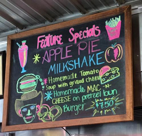 Chalkboard menu featuring specials: apple pie milkshake, tomato soup with grilled cheese, mac-n-cheese burger, $7.50.
