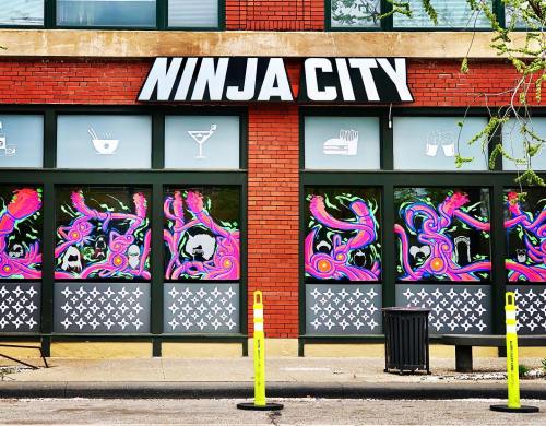 Colorful storefront of "Ninja City" featuring vibrant window art and a modern design.