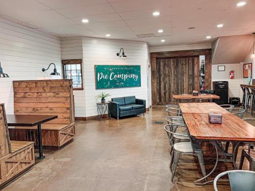 A cozy pie shop interior featuring wooden tables, benches, and a green sign reading "Walnut Valley Pie Company."