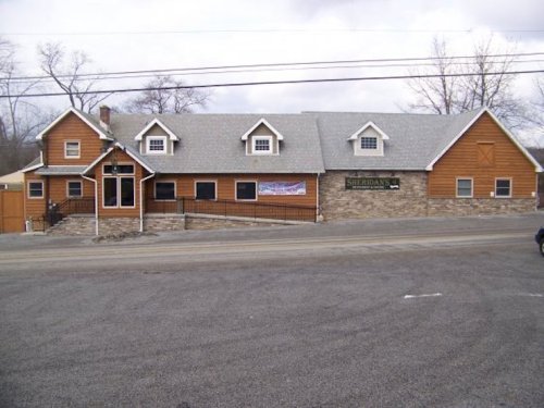 A large, rustic building with a stone foundation and wooden exterior, featuring multiple windows and a sign that reads "Sheridan's."