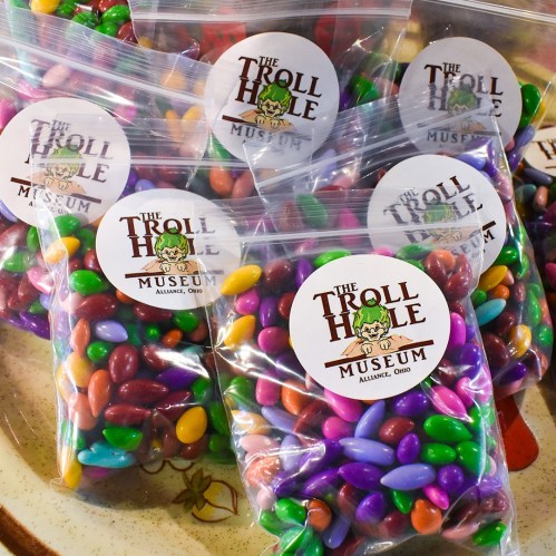 Colorful candy bags with a logo for "The Troll Hole Museum" in Alliance, Ohio, displayed on a plate.