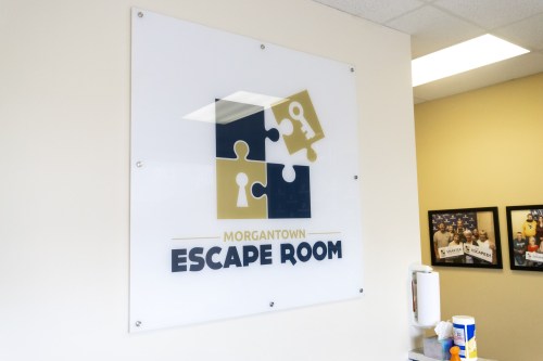 Sign for Morgantown Escape Room featuring a puzzle piece design and the text "ESCAPE ROOM."