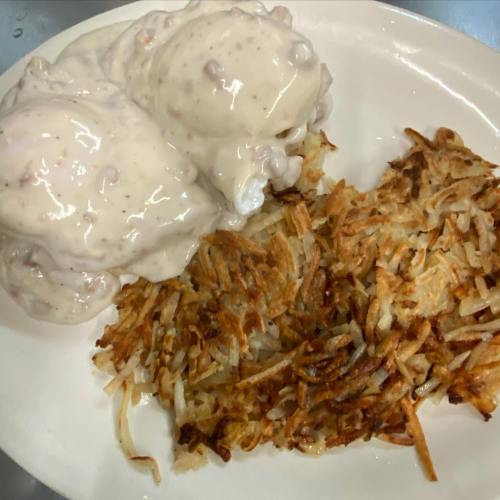 A plate with two servings of creamy dessert and a side of crispy golden hash browns.