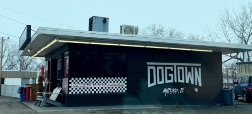 Exterior of Dogtown, a food establishment in Milford, CT, featuring a black and white checkered design and bold signage.
