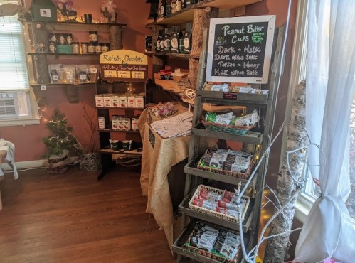 A cozy shop interior with shelves displaying peanut butter cups and other treats, decorated with rustic elements.