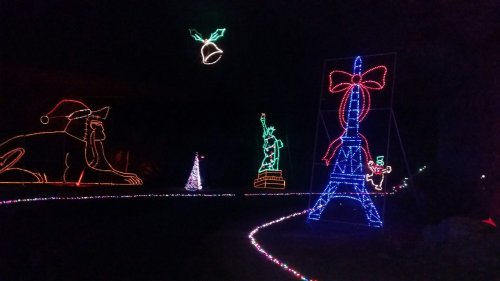 Colorful holiday lights display featuring iconic landmarks like the Statue of Liberty and the Eiffel Tower.