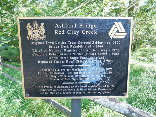 Plaque detailing the history and rehabilitation of Ashland Bridge over Red Clay Creek, including project management information.