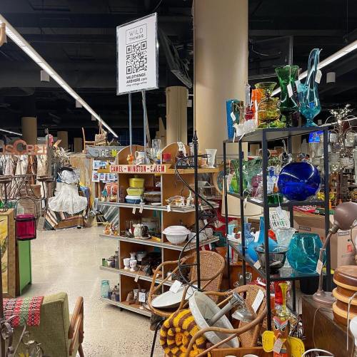 A vibrant thrift store aisle filled with various vintage items, glassware, and decorative pieces on display.