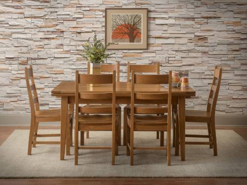 A wooden dining table surrounded by chairs, set against a stone wall and featuring a framed tree artwork.