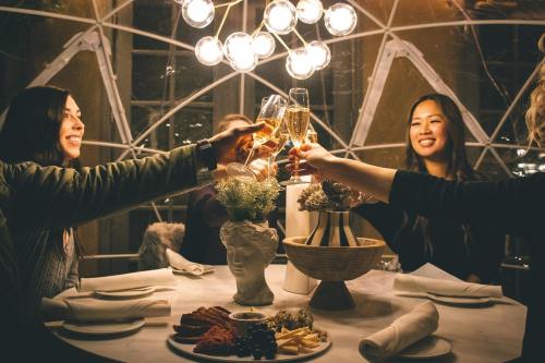 A group of friends toasting with champagne glasses at a stylish dinner table, surrounded by elegant decor.