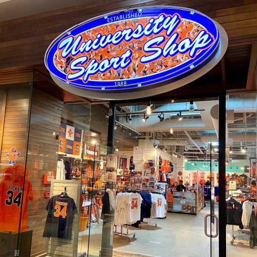 Sign for "University Sport Shop" with merchandise displayed inside a retail store.