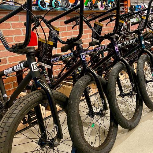 A row of bicycles with thick tires displayed against a brick wall in a shop.