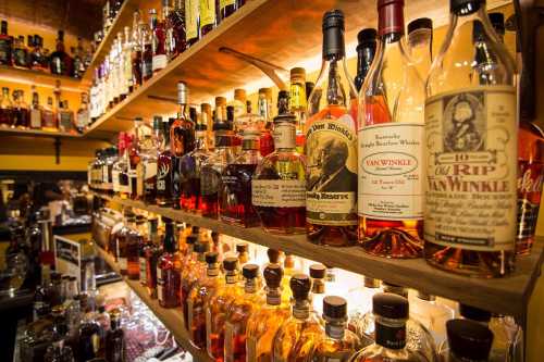 A wooden shelf filled with various bottles of whiskey and bourbon, showcasing different brands and labels.