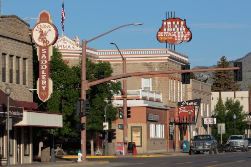 Historic street scene featuring Irma Hotel and local shops in a small town, with traffic lights and clear blue skies.