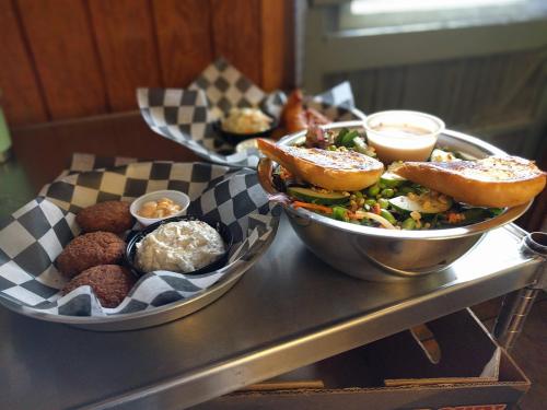 A tray with two bowls: one with salad and dressing, the other with fried items and a side of coleslaw.