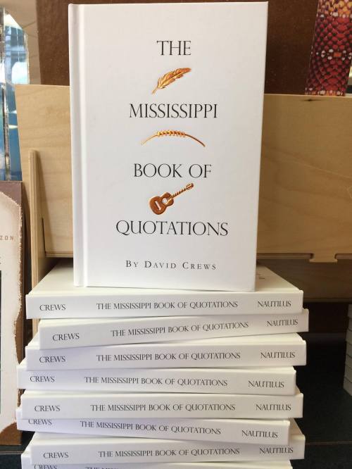 A stack of books titled "The Mississippi Book of Quotations" by David Crews, featuring a guitar and wheat design on the cover.