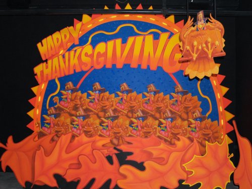 Colorful Thanksgiving-themed backdrop featuring turkeys in hats, musical instruments, and autumn leaves.