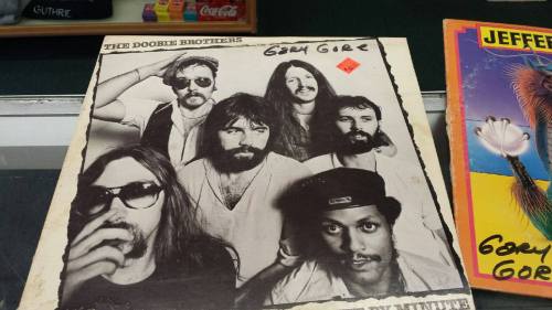 Black and white album cover featuring The Doobie Brothers, with six members posing together.