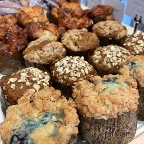 A variety of baked goods, including muffins and pastries, displayed on a tray.
