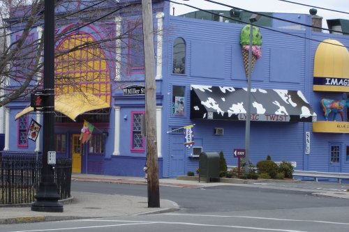 Colorful building with ice cream shop, bright signage, and a whimsical design, set in an urban environment.