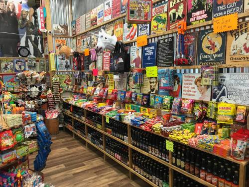 A colorful candy store filled with various sweets, snacks, and quirky signs on the walls.