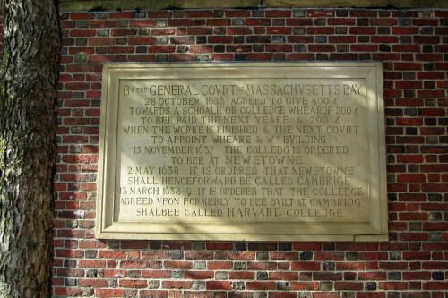 Historical plaque detailing the founding of Harvard College, with dates and agreements from the Massachusetts Bay Colony.