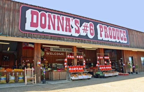 Exterior of Donna's #6 Produce store, featuring fresh fruits and vegetables, with a welcoming sign and rustic wooden design.