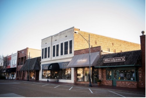 A charming street view of shops with brick facades and awnings, showcasing a quaint downtown area.