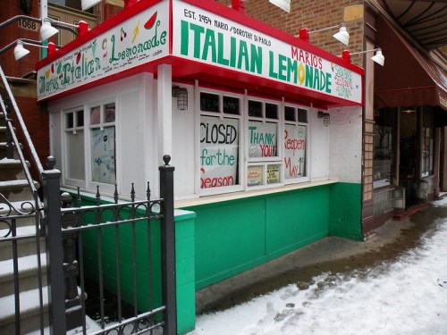 A colorful lemonade stand with signs saying "Closed for the season" and "Thank you!" in a snowy setting.