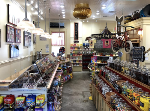A colorful candy store interior with jars of sweets, shelves of snacks, and vintage decor.