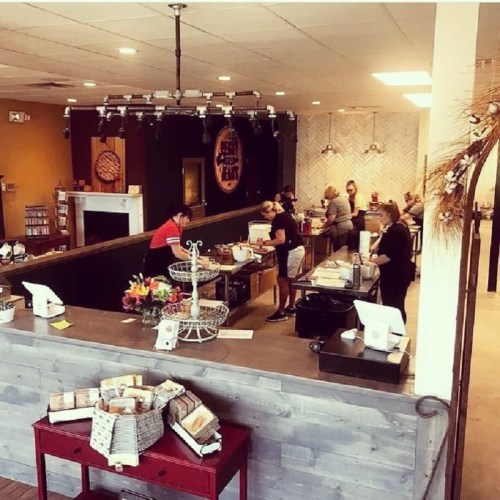 A cozy café interior with a counter, customers ordering, and staff preparing drinks in a warm, inviting atmosphere.