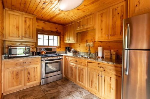 Cozy wooden kitchen with granite countertops, stainless steel appliances, and warm lighting.