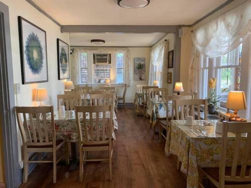 Cozy dining area with wooden tables, floral tablecloths, and soft lighting from lamps, creating a warm atmosphere.