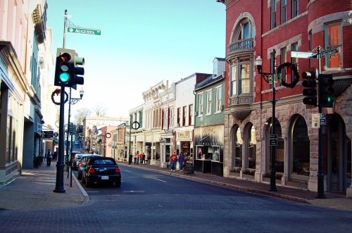 A quiet street scene with shops, traffic lights, and holiday decorations in a charming downtown area.