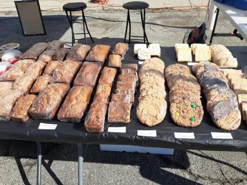 A table displaying a variety of baked goods, including loaves of bread and assorted cookies, all neatly packaged.