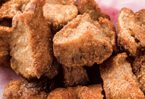 Crispy, golden-brown pieces of fried meat piled together on a plate.