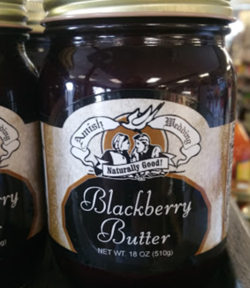 A jar of Blackberry Butter with a vintage label, featuring a couple and the text "Amish Wedding Naturally Good."