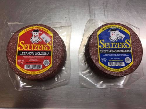 Two packages of Seltzer's Lebanon Bologna, one labeled "Sweet" and the other "Naturally Wood-Smoked," on a metal surface.
