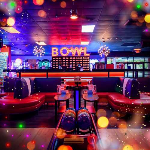 A vibrant bowling alley interior with colorful seating, neon lights, and a festive atmosphere.