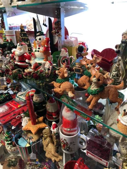 A festive display of Christmas decorations, including Santa, reindeer, snowmen, and various ornaments on shelves.