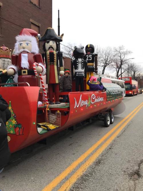 A festive Christmas parade float featuring Santa, nutcrackers, and a decorated Christmas tree.