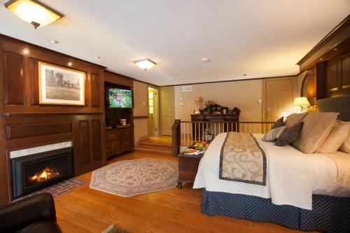 Cozy bedroom with a fireplace, TV, and elegant decor, featuring wooden accents and warm lighting.