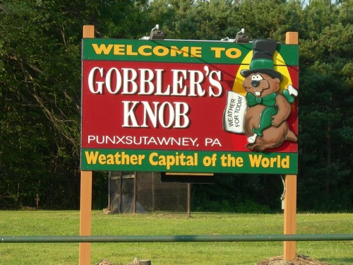 Sign welcoming visitors to Gobbler's Knob, Punxsutawney, PA, featuring a cartoon groundhog and "Weather Capital of the World."