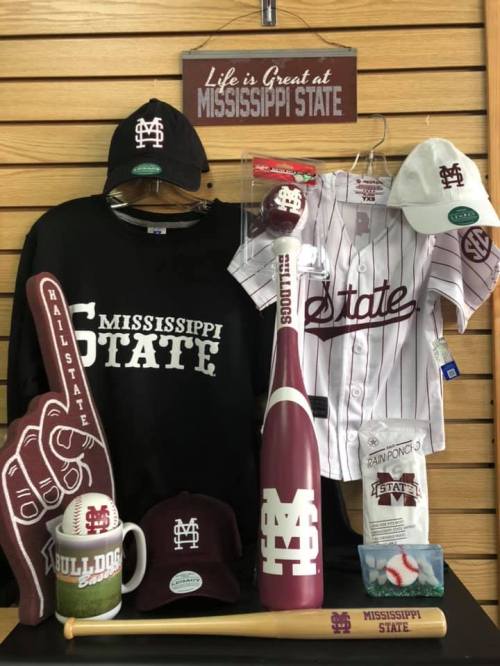 Merchandise display featuring Mississippi State apparel, accessories, and memorabilia, including a jersey, cap, and foam finger.