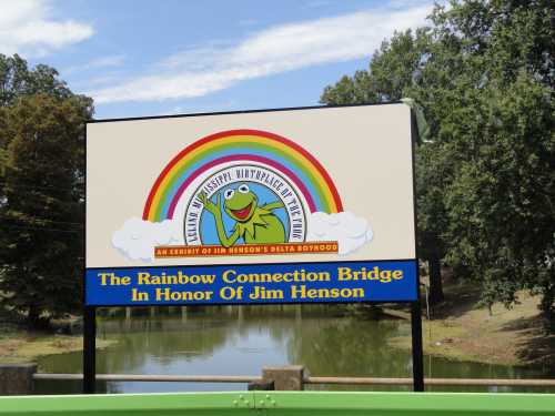 Sign for the Rainbow Connection Bridge, honoring Jim Henson, featuring Kermit the Frog and a colorful rainbow.