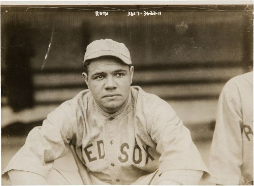 A sepia-toned photo of a young baseball player in a Red Sox uniform, sitting and looking thoughtfully at the camera.